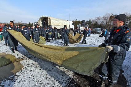 Сотрудники МЧС России ставят свою часть лагеря в международном лагере спасателей после сильнейшего землетрясение и цунами в Японии.