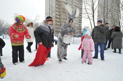 Празднование Масленицы. Бег в мешках. На снимке: аниматор в костюме зайца и дети.