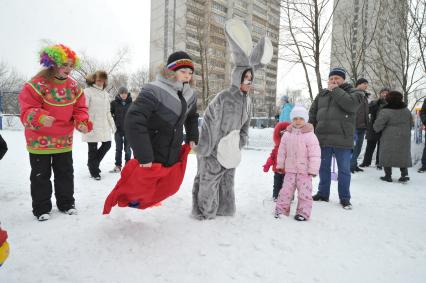 Празднование Масленицы. Бег в мешках. На снимке: аниматор в костюме зайца и дети.