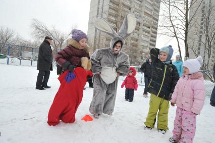 Празднование Масленицы. Бег в мешках. На снимке: аниматор в костюме зайца и дети.