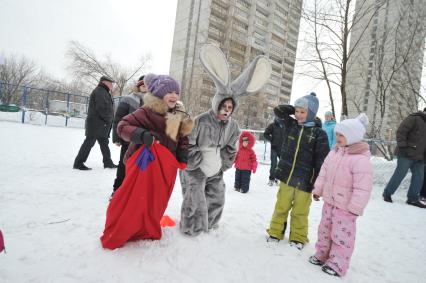 Празднование Масленицы. Бег в мешках. На снимке: аниматор в костюме зайца и дети.