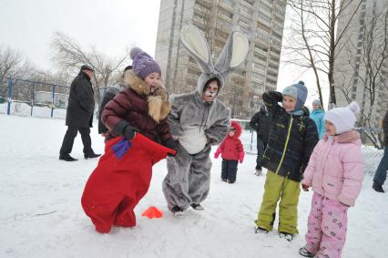 Празднование Масленицы. Бег в мешках. На снимке: аниматор в костюме зайца и дети.