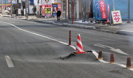 В Японии, после разрушительного землетрясения и цунами. Общие виды на разрушения. Деформация асфальта на дороге.