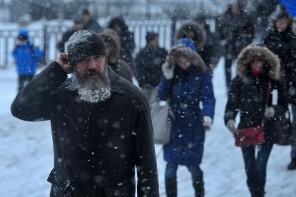 Снегопад в городе. На снимке: мужчина с бородой в морозную погоду.