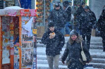 Снегопад в городе. На снимке: мужчина с булочкой.