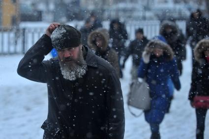 Снегопад в городе. На снимке: мужчина с бородой в морозную погоду.