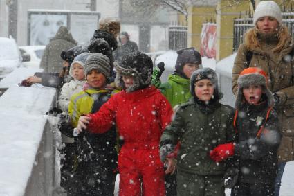 Снегопад в городе. На снимке: дети на зимней прогулке.