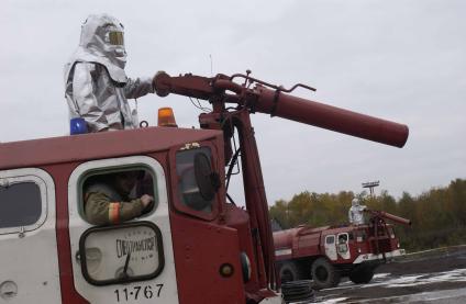 В рамках учений пожарная команда готовится к тушению пожара.