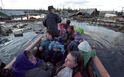 Последствия наводнения в Ленске 18 мая 2001 года. Мужчина вывозит местных жителей из зоны затопления.