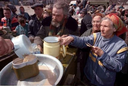 Раздача еды местным жителям на полевой кухне в Чечне.