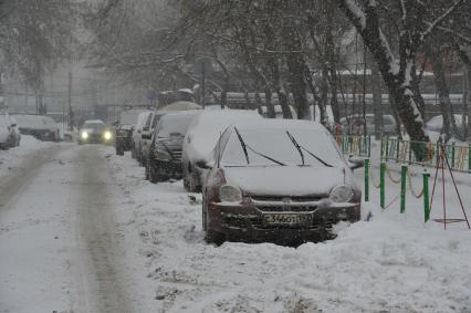 Снегопад в городе. На снимке: заснеженные автомобили.