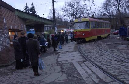 Трамвайная остановка в провинциальном городе вечером.