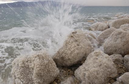 Мертвое море. Вода разбивается о камни, покрытые солью.