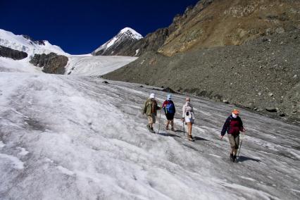 Группа туристов совершают пешую прогулку по леднику Ак-тру.