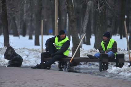 Гастарбайтеры сидят на лавочке в парке.