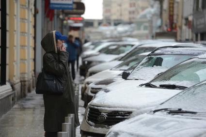 Ожидание. На снимке: женщина курит у припаркованных автомобилей.