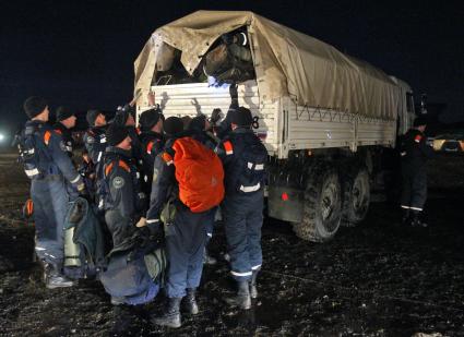 Спасатели загружают вещи в грузовик.