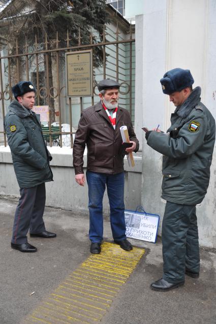 У посольства Белоруссии в Москве прошел пикет. На снимке: Полицейские проверяют документы у мужчины, который участвует в акции против смертной казни в Белоруссии. Храм Косьмы и Дамиана на Маросейке (на заднем плане).