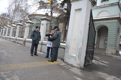 У посольства Белоруссии в Москве прошел пикет. На снимке: Полицейские проверяют документы у мужчины, который участвует в акции против смертной казни в Белоруссии. Храм Косьмы и Дамиана на Маросейке (на заднем плане).