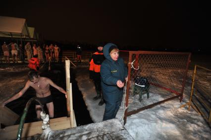 Крещение Господне. Крещенское купание. На снимке: мужчина поднимается по лестнице из проруби.