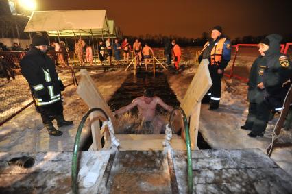 Крещение Господне. Крещенское купание. На снимке: мужчина поднимается по лестнице из проруби.