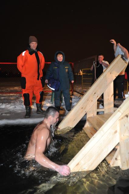 Крещение Господне. Крещенское купание. На снимке: мужчина поднимается по лестнице из проруби.