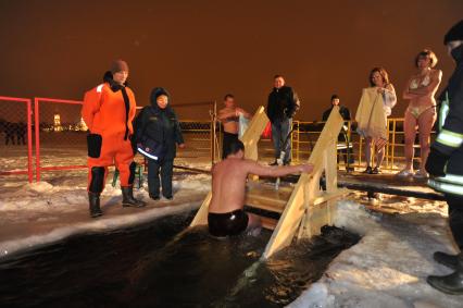 Крещение Господне. Крещенское купание. На снимке: мужчина поднимается по лестнице из проруби.