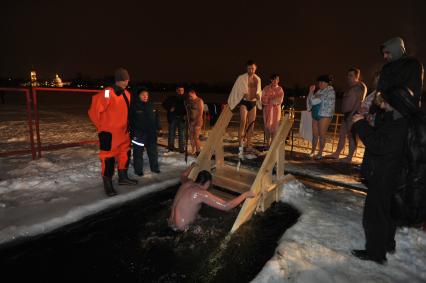 Крещение Господне. Крещенское купание. На снимке: мужчина поднимается по лестнице из проруби.