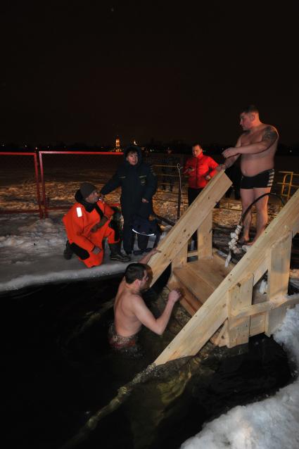 Крещение Господне. Крещенское купание. На снимке: мужчина поднимается по лестнице из проруби.