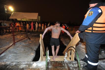 Крещение Господне. Крещенское купание. На снимке: мужчина опускается по лестнице в прорубь.