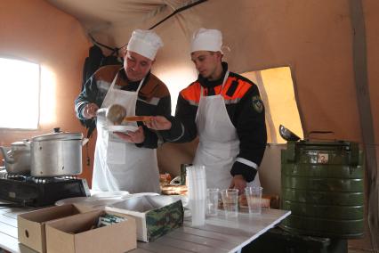 Передвижной лагерь спасателей в Японии во время спасательных работ, после землетрясения и цунами. На снимке повар с помощником.