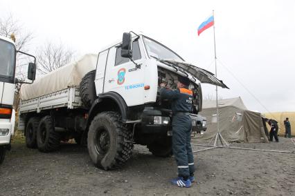 Спасатели МЧС в Японии во время спасательных работ, после землетрясения и цунами. На снимке спасатель проверяет исправность грузового автомобиля `КАМАЗ`.