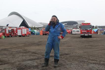 Спасатели МЧС в Японии во время спасательных работ, после землетрясения и цунами. В международном лагере спасателей сотрудник МЧС разговаривает по телефону.