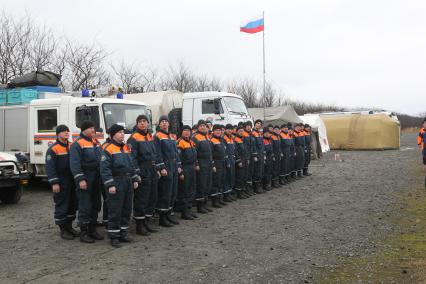 Спасатели МЧС в Японии во время спасательных работ, после землетрясения и цунами. Утреннее построение около мобильного лагеря.