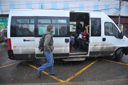 Мужчина подходит к маршрутному автобусу.