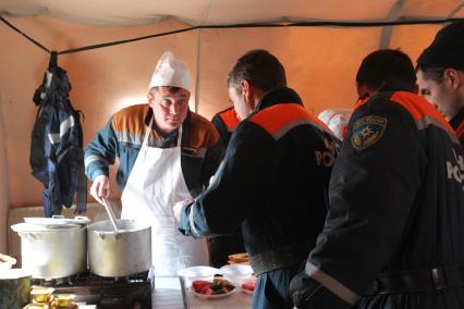 Во время спасательных работ, после землетрясения и цунами в Японии. В столовой повар раздает еду.