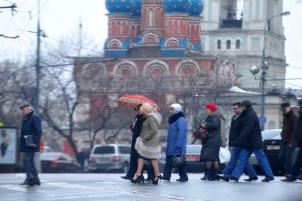 Люди переходят дорогу по пешеходному переходу.