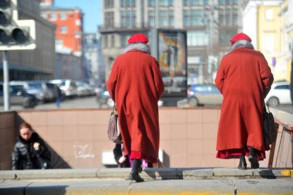 Женщины близнецы идут по городу.