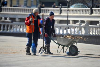 Женщины- гастарбайтеры занимаются уборкой города.