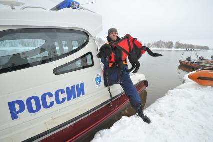 Коломенский район. Показное тактико-специальное учение  Коломенского районного звена Московской областной системы предупреждения и ликвидации чрезвычайных ситуаций по ликвидации последствий весеннего половодья на территории района. На снимке: специалист-кинолог МЧС со служебной собакой у спасательного катера МЧС.