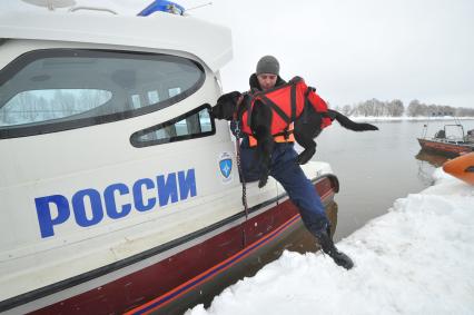 Коломенский район. Показное тактико-специальное учение  Коломенского районного звена Московской областной системы предупреждения и ликвидации чрезвычайных ситуаций по ликвидации последствий весеннего половодья на территории района. На снимке: специалист-кинолог МЧС со служебной собакой у спасательного катера МЧС.