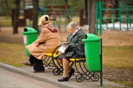 Детский парк. Усадьба Трубецких в Хамовниках. На фото: пожилая женщина читает газету.