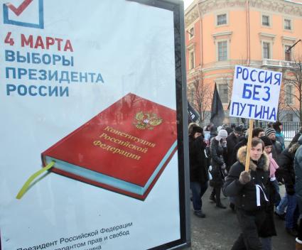 Митинг за честные выборы. Рядом с рекламой про выборы президента России идет мужчина с плакатом: `Россия без Путина`.