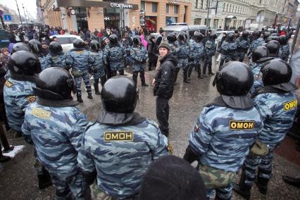 Митинг за честные выборы. Мужчина стоит в кольце из сотрудников ОМОНа.