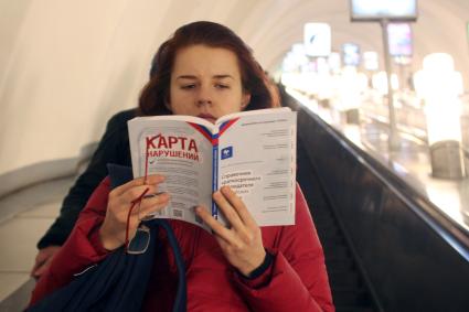 Девушка в метро читает книгу на которой написано: `Карта нарушений`.