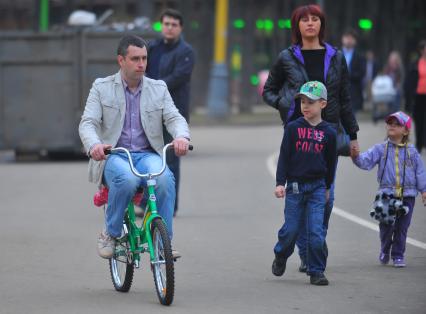 Весна в парке Сокольники. На снимке: мужчина едет на детском велосипеде.