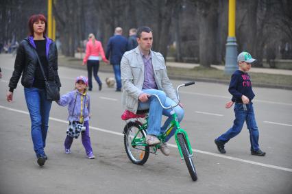 Весна в парке Сокольники. На снимке: мужчина едет на детском велосипеде.