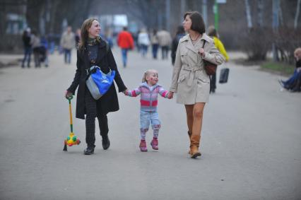 Весна в парке Сокольники. На снимке: две девушки идут с ребенком по парку.