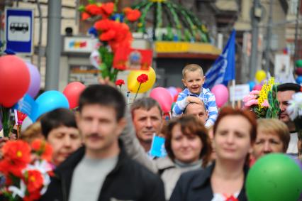 Участники первомайского шествия на улицах Москвы. На снимке: ребенок сидит на плечах отца.