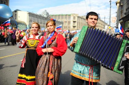 Участники первомайского шествия на улицах Москвы. На снимке: мужчина играет на гармони.